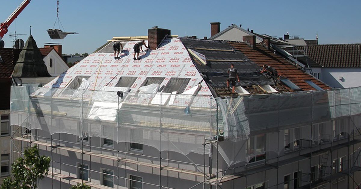 Roofers using fall protection harnesses