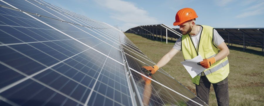 worker inspecting solar panels